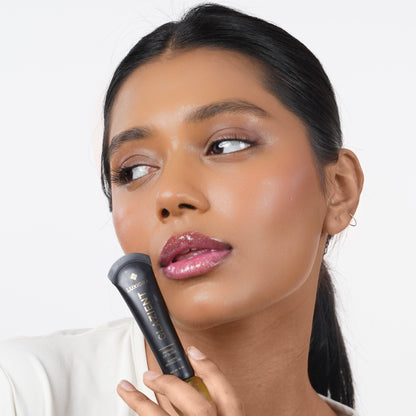 Moonlit Indian woman with medium skin applying Glazient Moonlit clear lip gloss