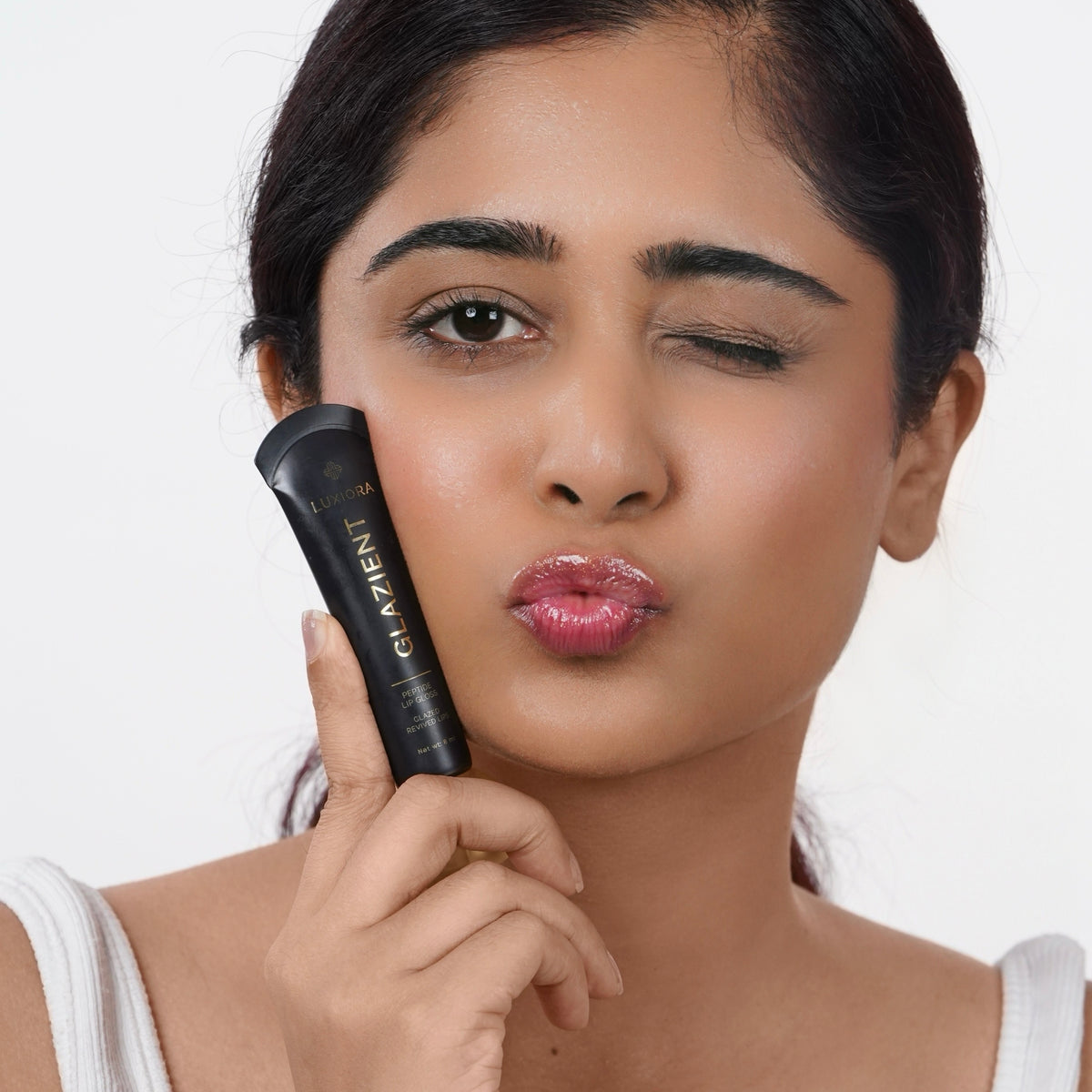 Moonlit Indian woman with fair skin applying Glazient Moonlit sheer lip gloss