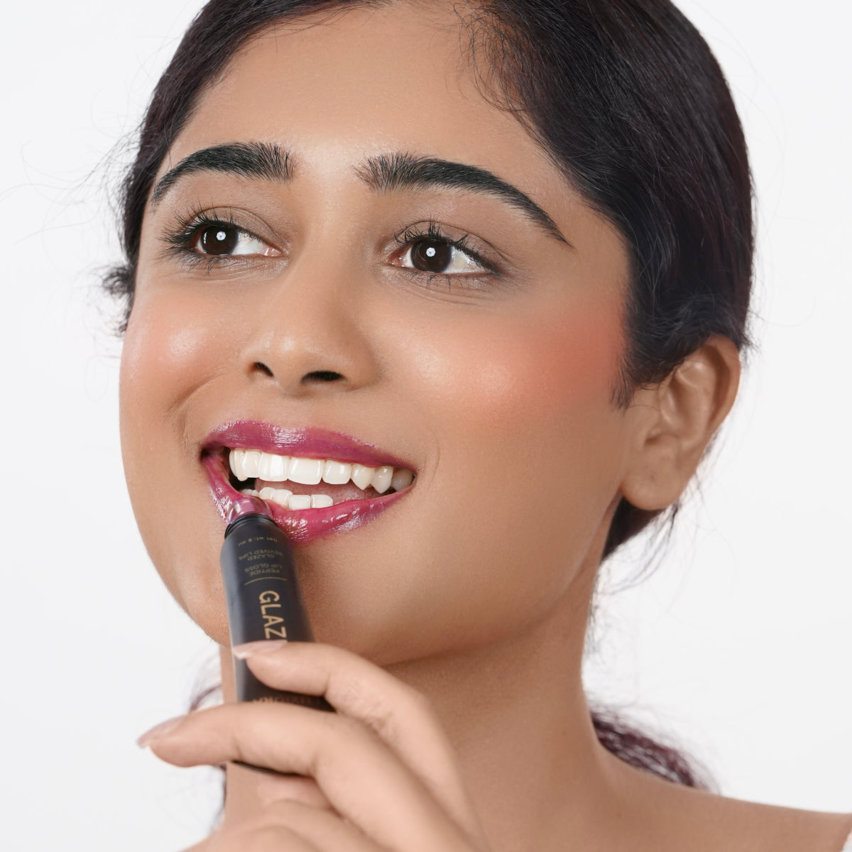 Rose_Pink Indian woman with fair skin applying purple lip gloss
