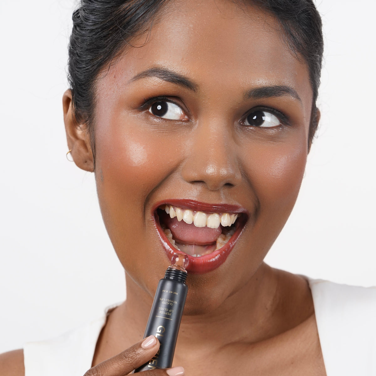 Toasted_Nude Indian woman with dark skin applying Glazient Toasted Nude nude lip gloss