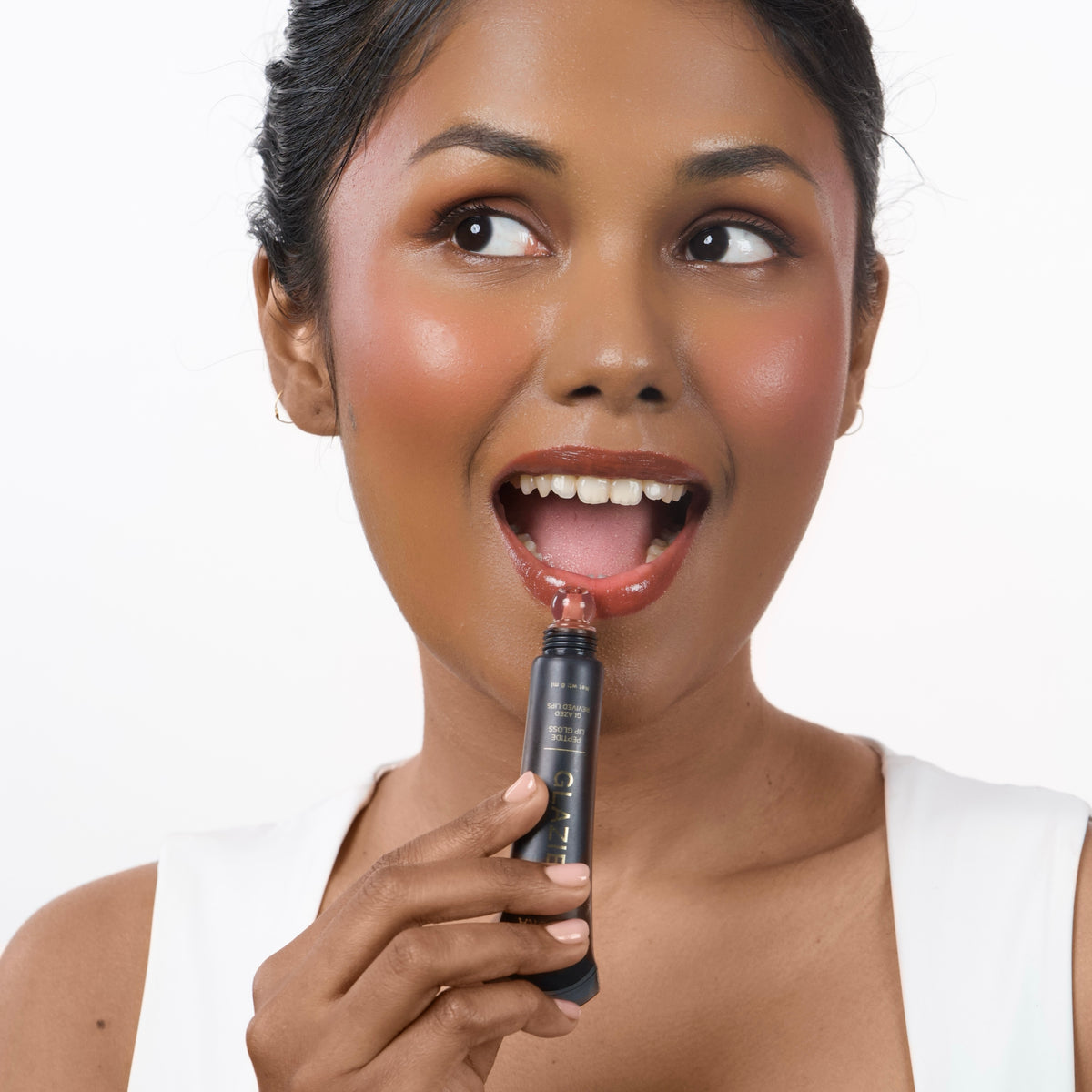 Warm_Caramel Indian woman with dark skin applying Glazient Warm Caramel nude lip gloss
